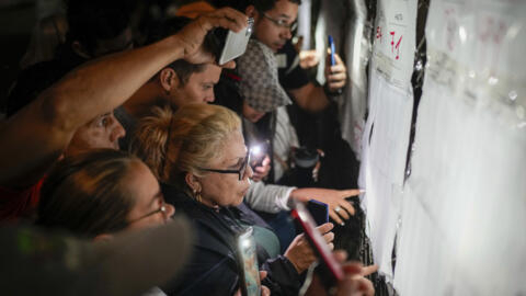 Eleitores verificam listas eleitorais na véspera da abertura das seções de votação na Venezuela. (28/07/2024)