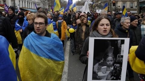 2024年2月24日，在巴黎举行的支持乌克兰游行中，示威者裹着乌克兰国旗。
