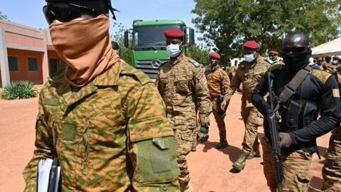 Burkina Faso's junta leader Captain Ibrahim Traore (C) leaves the General Sangoule Lamizana military camp in Ouagadougou on 8 October, 2022, following the funerals of 27 soldiers killed as they escorted 207-vehicles in a convoy in Gaskinde.