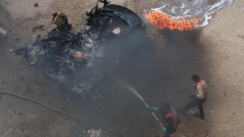 Des Palestiniens éteignent une voiture en feu touchée par une frappe israélienne, à Rafah, dans le sud de la bande de Gaza, le 10 février,