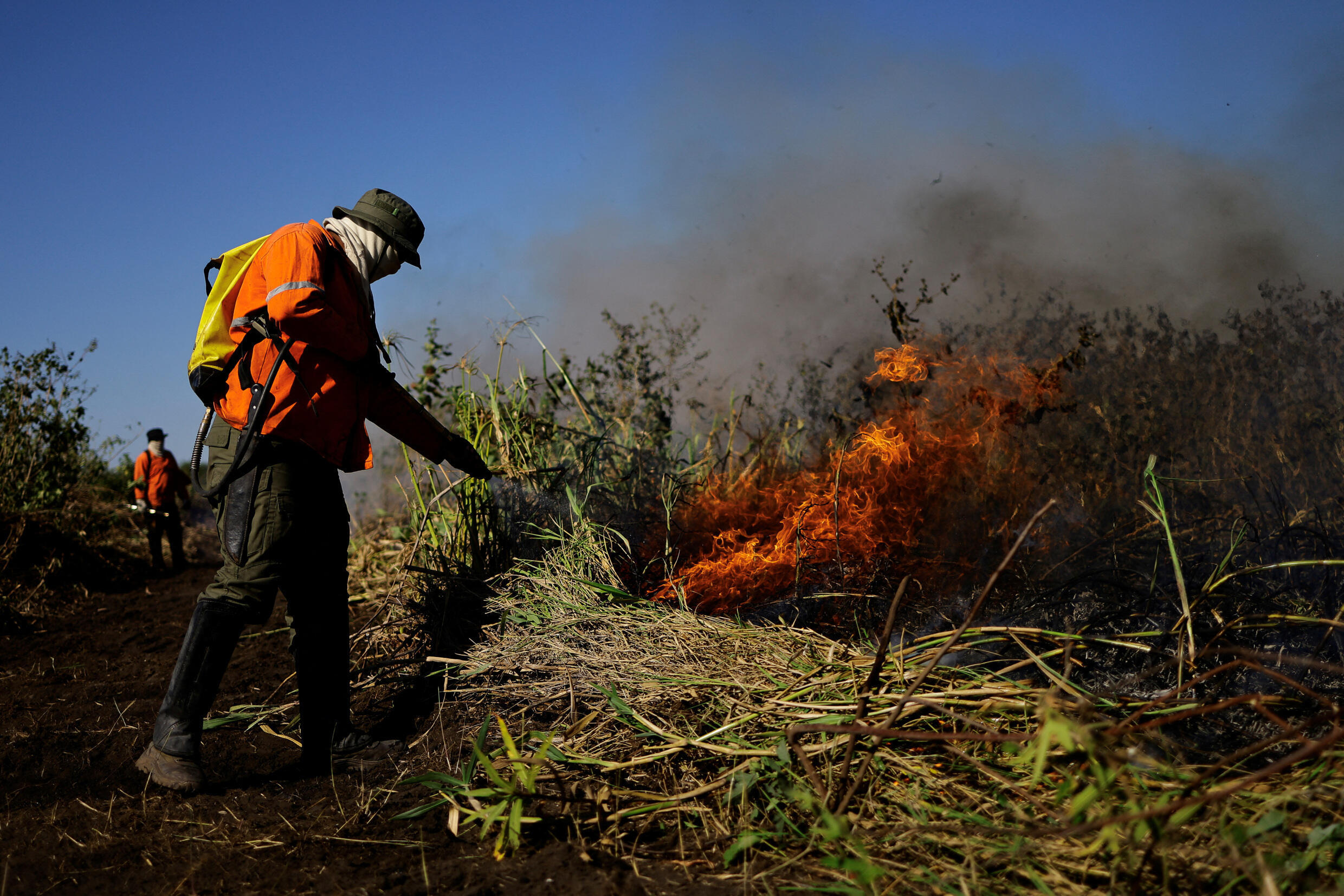 Bombeiros voluntários da Brigada do Alto Pantanal trabalham para apagar um incêndio. Pantanal é a maior área úmida do mundo, mas está sofrendo com as secas recorrentes. (14/06/2024)