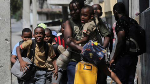 Crianças correm em busca de segurança ao deixarem a escola em meio à violência de gangues em Porto Príncipe, Haiti, em 3 de março de 2023.