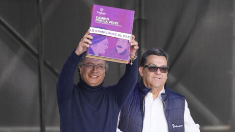 El presidente de Colombia, Gustavo Petro, izquierda, sostiene una copia de una ley que reforma el sistema de pensiones, cumpliendo una promesa de campaña de que las personas mayores que viven en la pobreza obtengan un ingreso básico del estado, en Bogotá, Colombia, el martes 16 de julio de 2024.