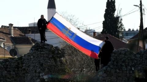 Steagul Serbiei afișat de protestatari în fața Parlamentului Republicii Muntenegru, înaintea votării unei legi referitoare la libertatea religioasă, 26 decembrie 2019