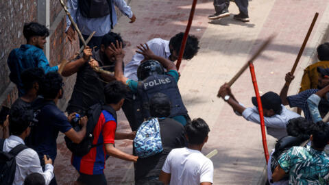 Un agente de policía es golpeado por la multitud en el distrito de Rampura de Daca, Bangladesh, el 18 de julio de 2024. 