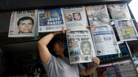Un vendeur met en place des journaux rapportant l'arrestation à El Paso aux États-Unis, du baron de la drogue mexicain Ismael Zambada, alias El Mayo et de Joaquin Guzman Lopez, l'un des fils d'El Chapo. Mexico, Mexique, le 26 juillet 2024.