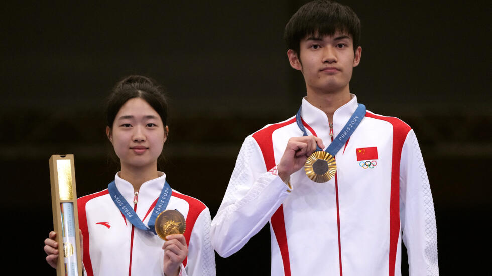 Los medallistas de oro Huan Yuting (izquerda) y Sheng Lihao (derecha) de China posan con sus medallas. París, 27 de julio 2024.