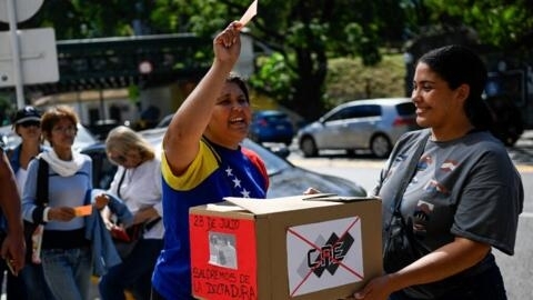 Eleitores venezuelanos simulam voto diante da embaixada da Venezuela em Buenos Aires, em 25 de março de 2024, para protestar contra as dificuldades para participar da eleição de 28 de julho.
