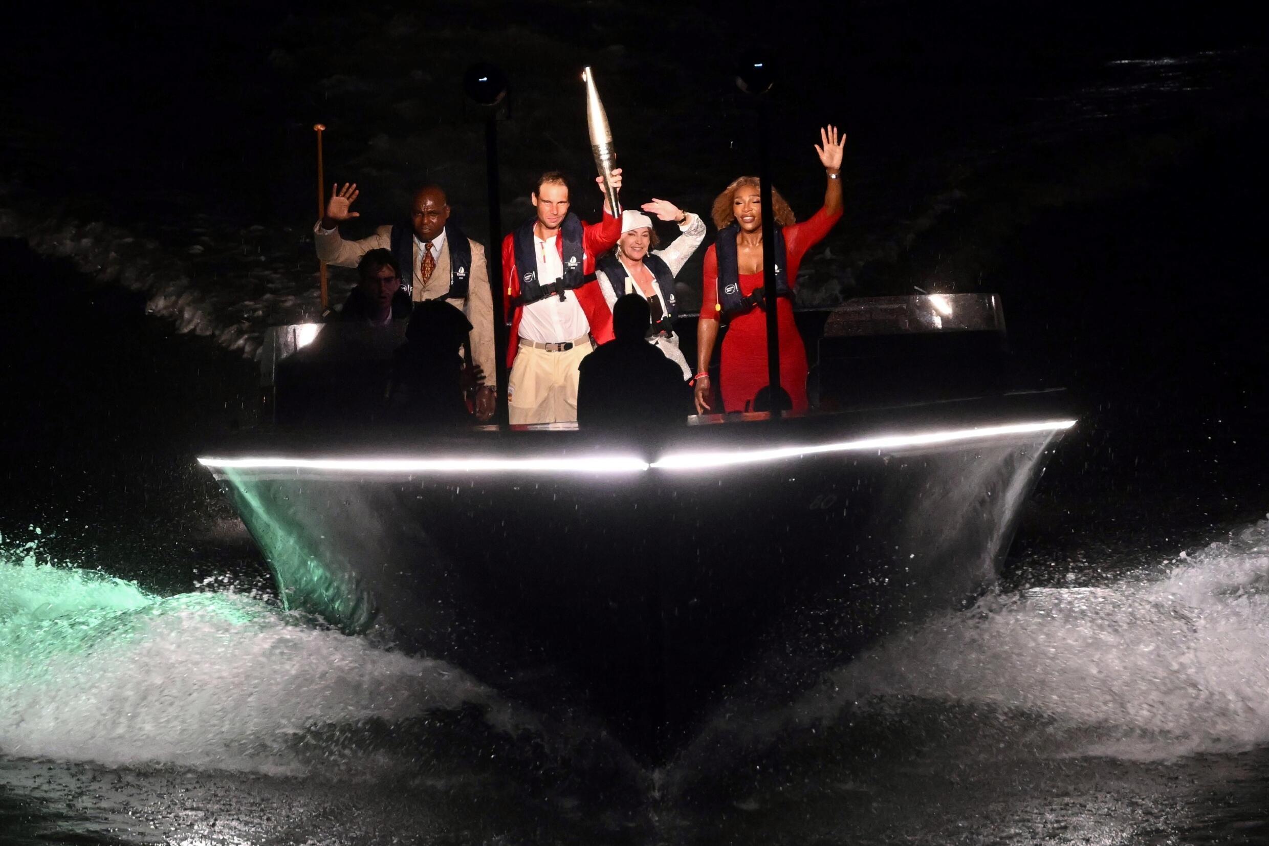 De izquierda a derecha: Carl Lewis, Rafa Nadal con la antorcha olímpica, Nadia Comaneci y Serena Williams, en un barco por el Sena durante la ceremonia de apertura de los Juegos Olímpicos de París, el 26 de julio de 2024