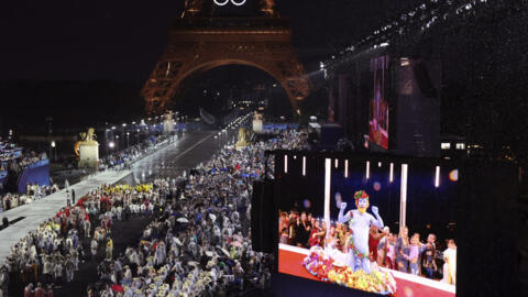 Delegations arrive at the Trocadero as spectators watch French singer Philippe Katerine performing on a giant screen, in Paris, during the opening ceremony of the 2024 Summer Olympics, Friday, July 26