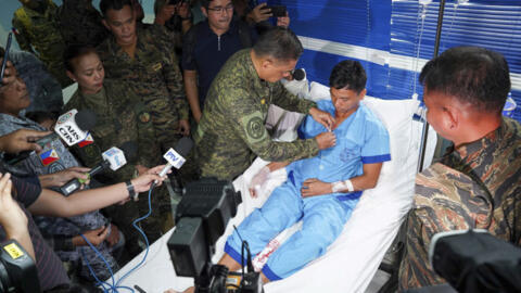 In this photo provided by Armed Forces of the Philippines, Philippine military chief General Romeo Brawner Jr. pins a medal on a Navy personnel in Palawan province, Philippines on Wednesday June 19, 2