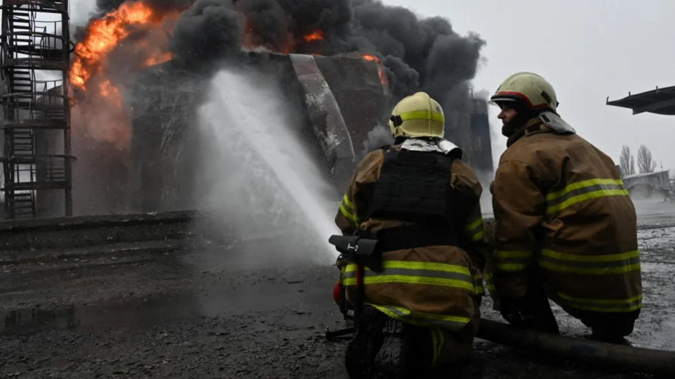 Deux pompiers ukrainiens sur le site de la station-service qui a été dévorée par les flammes, à Kharkiv , le 10 février 2024