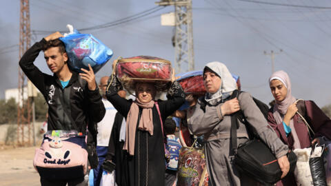 Palestinos que fogem da Cidade de Gaza e de outras partes do norte da Faixa de Gaza caminham em direção às áreas do sul ao longo de uma estrada, em 10 de novembro de 2023, devido aos combates entre o Hamas e o Exército israelense.