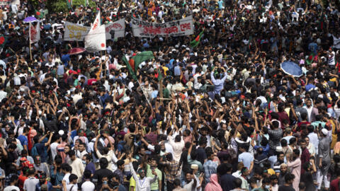 As pessoas gritam slogans enquanto participam num protesto contra a primeira-ministra Sheikh Hasina, que renunciou, e o seu governo exigindo justiça para as vítimas mortas nos recentes confrontos mortais em todo o país, em Daca, Bangladesh, segunda-feira, 5 de agosto de 2024.