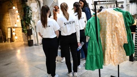 Vendedoras aguardam a chegada de convidados para a inauguração de uma loja pop-up da marca de moda chinesa Shein em Paris, em 4 de maio de 2023.
