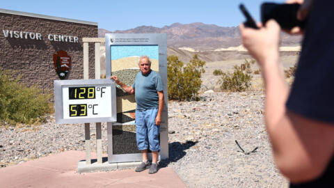 Um turista posa para foto ao lado de um termômetro que marca 53ºC, no Parque Nacional do Vale da Morte, nos EUA, em 09 de julho de 2024.