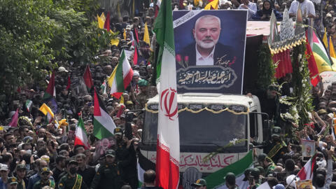 Iranians follow a truck, center, carrying the coffins of Hamas leader Ismail Haniyeh and his bodyguard who were killed in an assassination blamed on Israel on Wednesday, during their funeral ceremony 