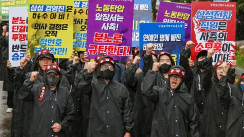 The National Samsung Electronics Union (NSEU) workers hold placards and shout slogans during a general strike to disrupt production between July 8 and 10, in front of the Samsung Electronics Nano City