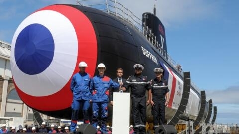 French President Emmanuel Macron (C) attends the official launch ceremony of the new French nuclear submarine "Suffren" in Cherbourg, north-western France on July 12, 2019. 