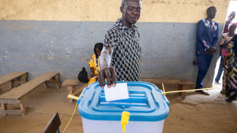 Un homme déposant son bulletin de vote dans un bureau de l'école du quartier Abena, Bureau 2 Carré 27, à Ndjamena le 6 mai 2024 lors de l'élection présidentielle au Tchad.