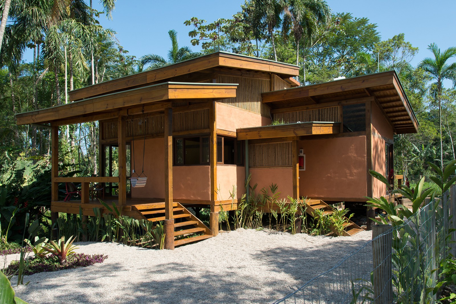 Situada em Ubatuba e parte do projeto Casa de Terra, feito por Elena Caldini e os arquitetos Marina Matulja e Marcelo Bueno, esta casa possui estrutura de eucalipto e pinus. Nomeada de Casa Jussara, este projeto é completamente elevado do chão, pensando na preservação do terreno natural e evitando uma possível terraplanagem