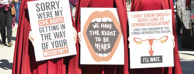 Ativistas vestidas de aia seguram cartazes a favor da manutenção dos direitos reprodutivos e sexuais na Marcha das Mulheres da Califórnia, em 19 de janeio de 2019 — Foto: Rodin Eckenroth/Getty Images