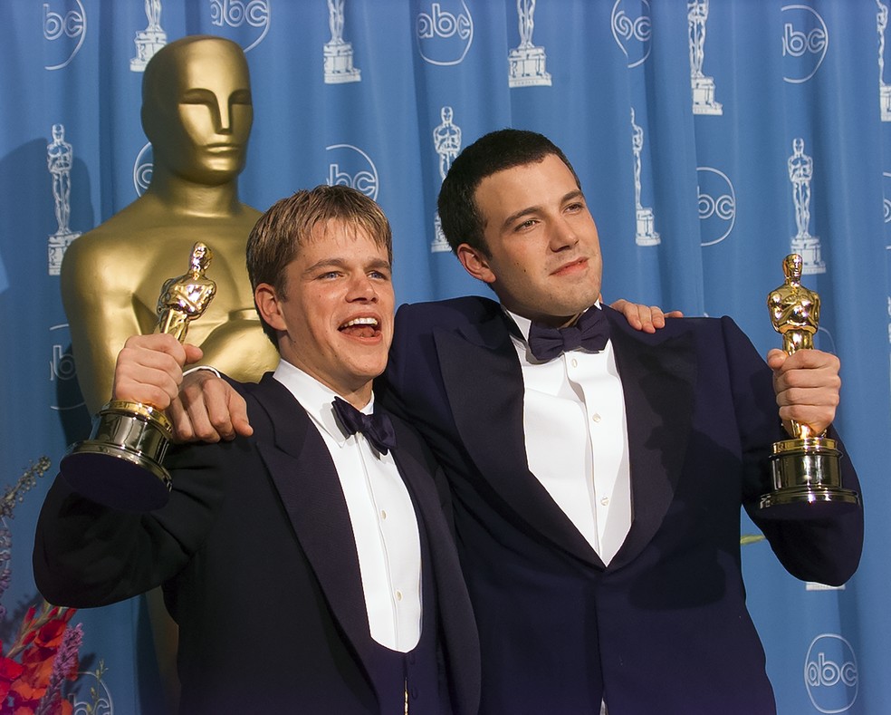 Matt Damon e Ben Affleck com as estatuetas do Oscar vencidas por eles em 1998, na categoria de melhor roteiro original, por Gênio Indomável (1997) — Foto: Getty Images