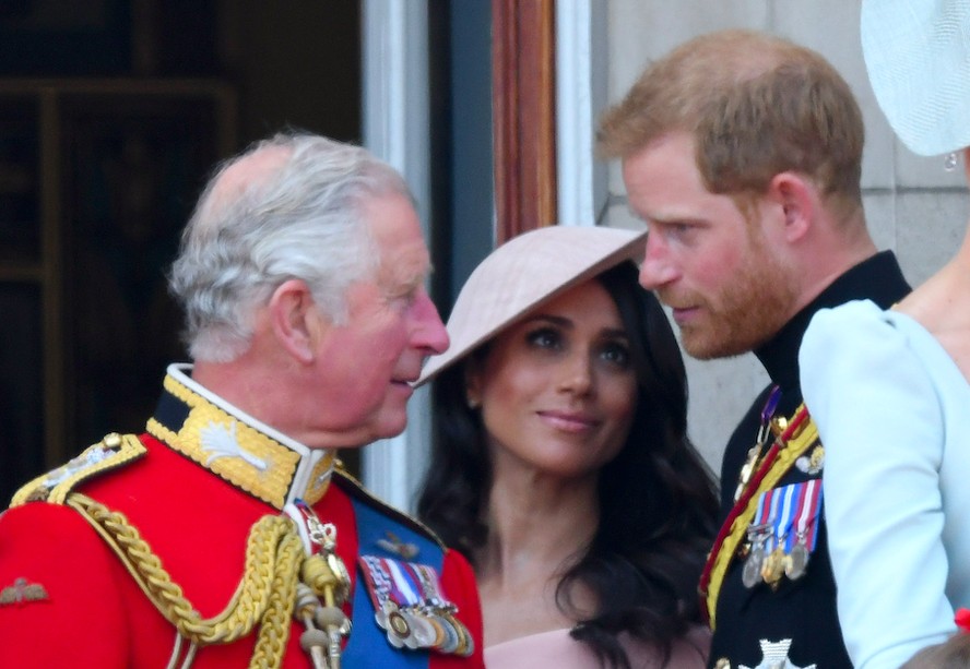 O Rei Charles III na companhia do Príncipe Harry e da atriz e Duquesa Meghan Markle em foto de 2018
