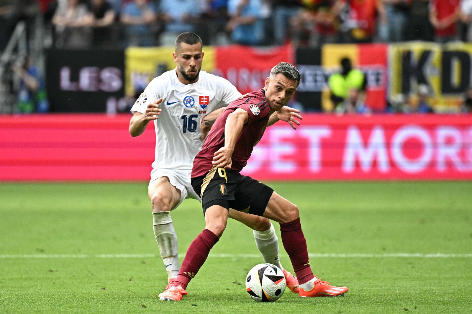 O zagueiro nº 16 da Eslováquia, David Hancko , luta pela bola com o meio-campista belga nº 09 Leandro Trossard durante a partida de futebol do Grupo E da UEFA Euro 2024 entre Bélgica e Eslováquia na Arena Frankfurt. Partida termina 1x0 para a Eslováquia. — Foto: JAVIER SORIANO / AFP