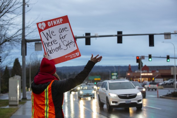 Um profissional de saúde da Kaiser Permanente faz piquete em frente a um centro médico em Clackamas, Oregon, EUA