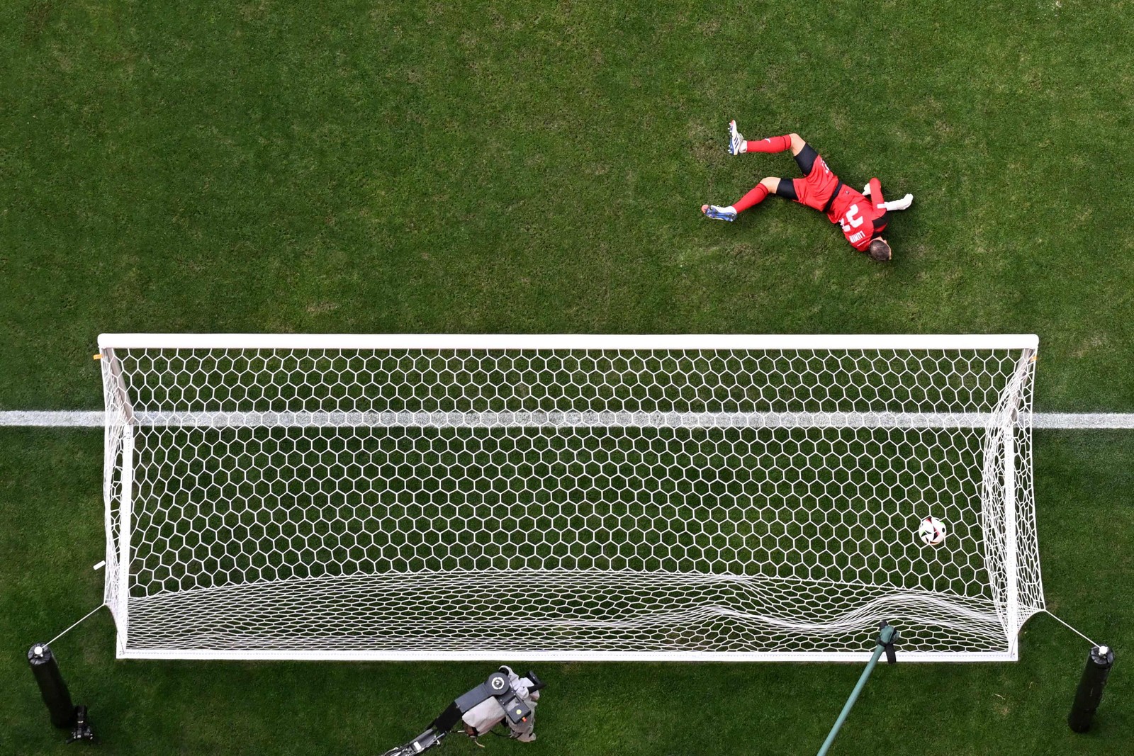 O goleiro ucraniano nº 23, Andriy Lunin, sofre o segundo gol do meio-campista romeno nº 18, Razvan Marin, durante a partida de futebol do Grupo E da UEFA Euro 2024 entre a Romênia e a Ucrânia, na Arena de Futebol de Munique. A partida terminou 3x0 para a Romênia.  — Foto: Ben Stansall / AFP