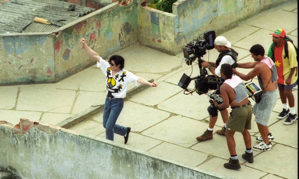 Michael Jackson durante gravação do clipe em uma laje no morro Dona Marta. Um ano após a morte do astro, em 2009, uma estátua de bronze foi inaugurada em sua homenagem — Foto: Jorge William / Agência O Globo