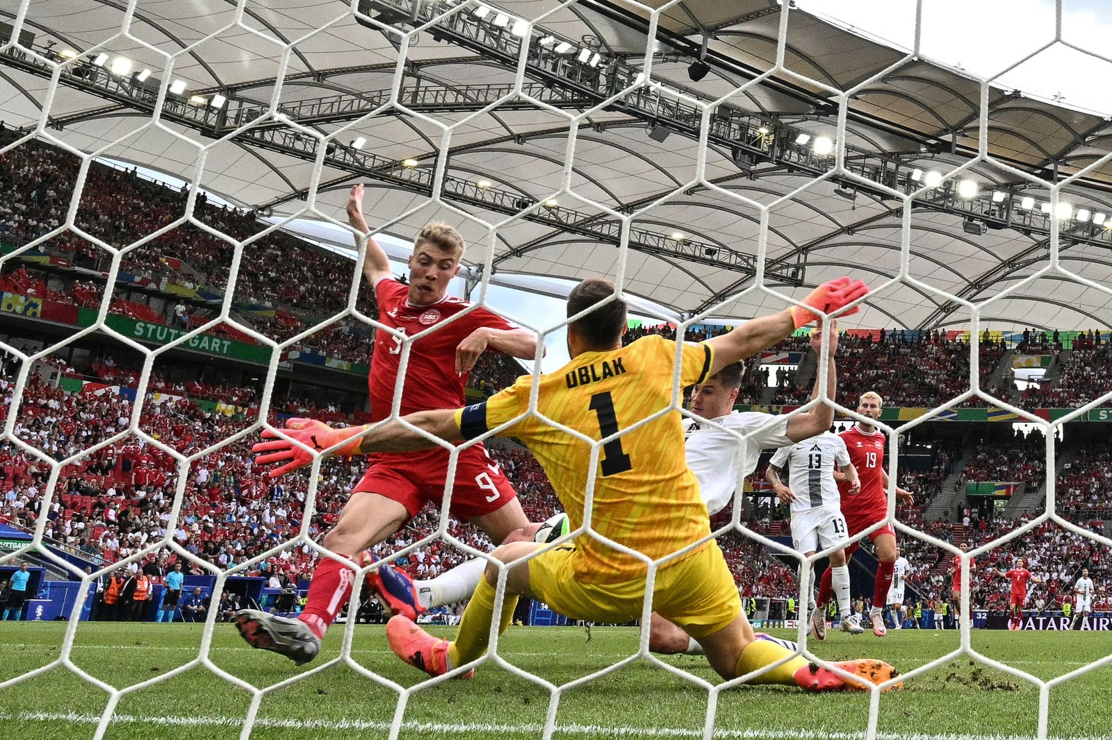 O atacante dinamarquês #09 Rasmus Hojlund luta pela bola com o goleiro esloveno #01 Jan Oblak durante a partida de futebol do Grupo C da UEFA Euro 2024 entre Eslovênia e Dinamarca na Stuttgart Arena, em Stuttgart — Foto: MIGUEL MEDINA / AFP