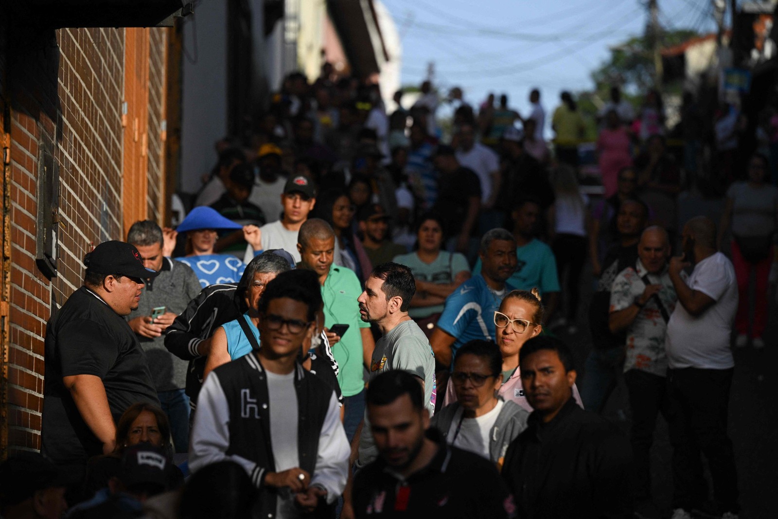 Pessoas fazem fila do lado de fora de uma seção eleitoral em Caracas durante disputa presidencial venezuelana — Foto: Federico PARRA / AFP