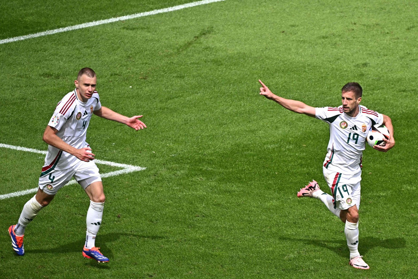 O atacante húngaro nº 19 Barnabas Varga (direita) comemora com o zagueiro húngaro nº 04 Attila Szalai depois de marcar o primeiro gol de seu time durante a partida de futebol do Grupo A da UEFA Euro 2024 entre Hungria e Suíça, no Estádio de Colônia — Foto: JAVIER SORIANO / AFP