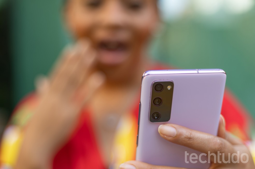 Mulher surpresa olhando para o celular — Foto: Mariana Saguias/TechTudo