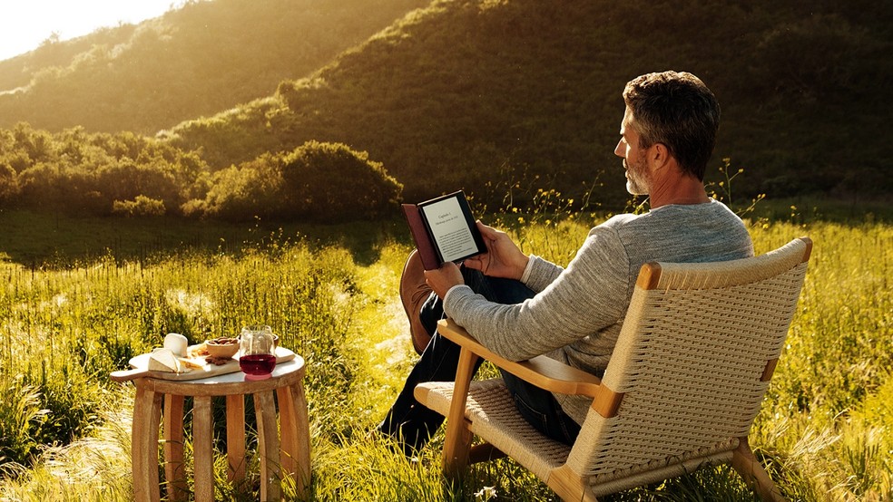 Homem lendo no Kindle ao ar livre  — Foto: Divulgação/Amazon