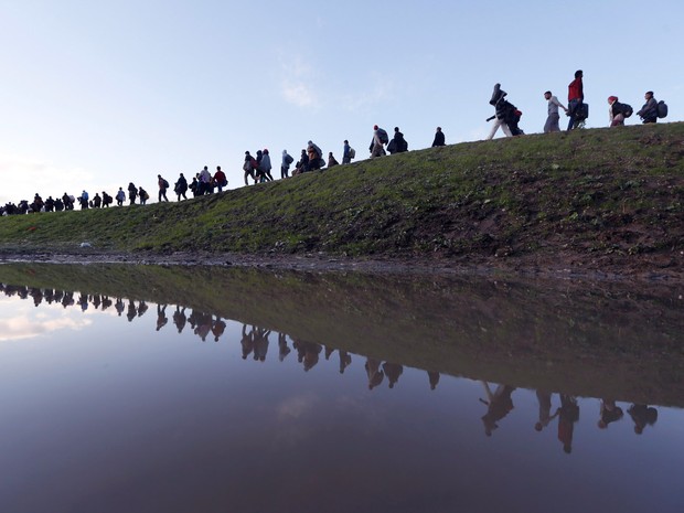 Migrantes caminham a pé nos arredores de Brezice, na Eslovênia. O Ministério do Interior do país levantou a possibilidade da criação de barreiras físicas ao longo de sua fronteira sudeste se o número de migrantes e refugiados aumentado (Foto: Srdjan Zivulovic/Reuters)