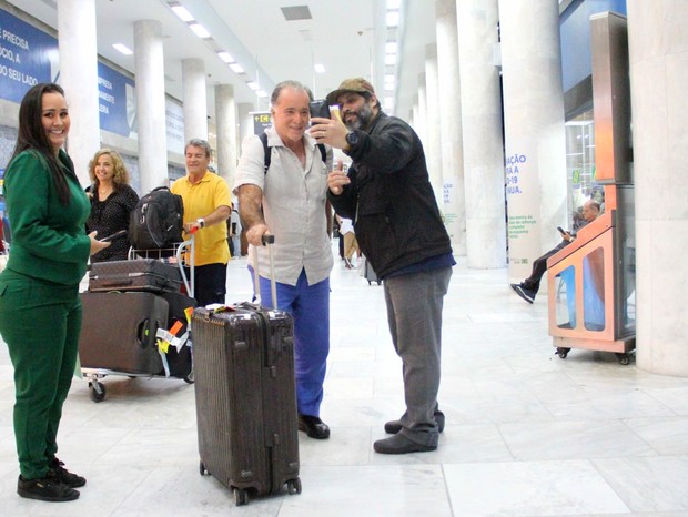 Tony Ramos posa com fã ao desembarcar com a mulher, Lidiane Barbosa, no Rio de Janeiro (Foto: Gabriel Rangel/AgNews)