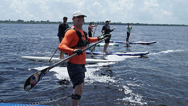 Cinco pessoas, incluindo Clayton e Carol, posando para a foto enquanto em pé standup no Rio Negro
