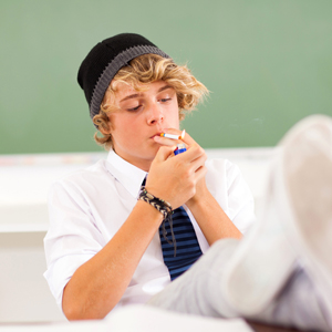 garoto branco fumando na sala de aula