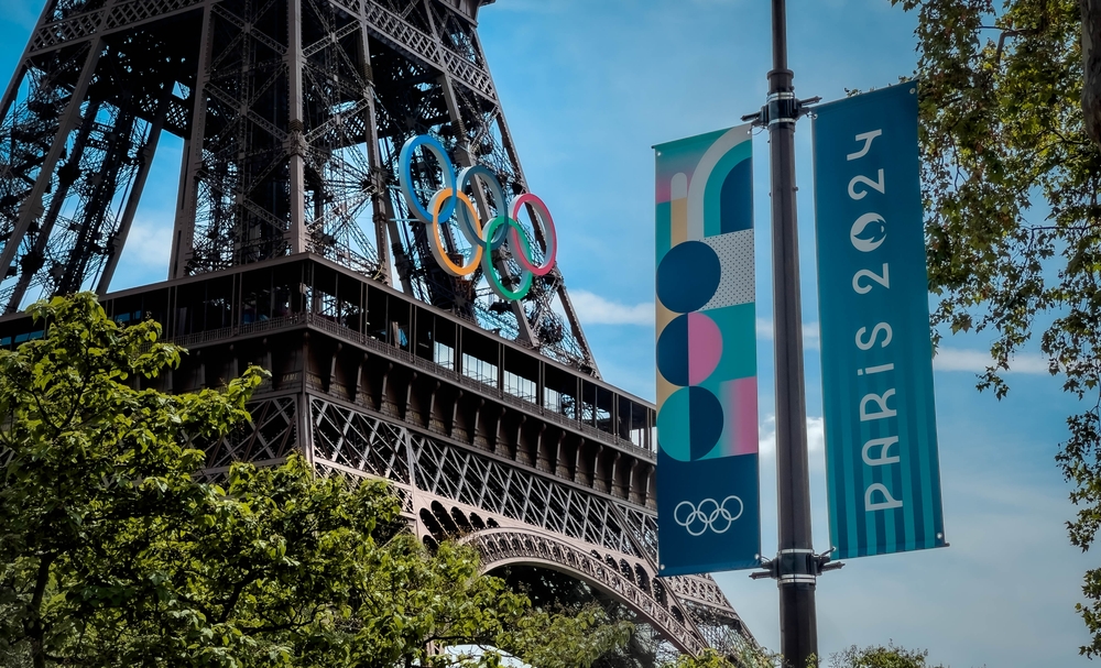 Torrei Eiffel e bandeira com logomarca das Olimpíadas de Paris 2024