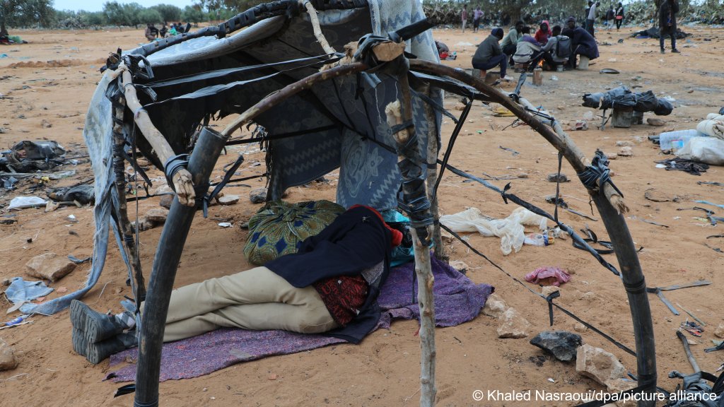 Un migrant noir allongé sous un reste de tente en périphérie de Sfax, en Tunisie. Crédit : Khaled Nasraoui / dpa / picture alliance