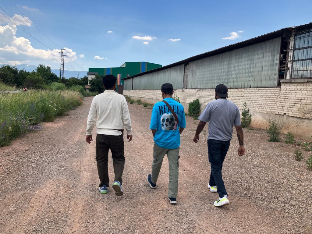 Three Indian friends near a warehouse where they do handling, after obtaining a one-year work permit |  Photo: InfoMigrants