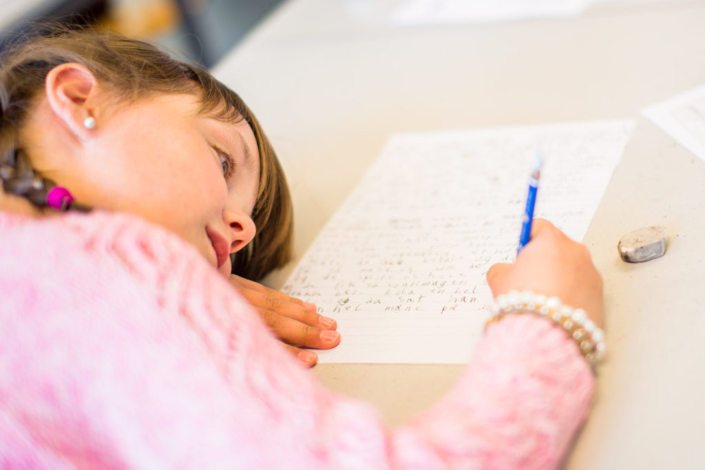 Barneskoleelev som skriver for hånd