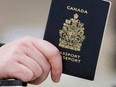 A passenger holds a Canadian passport before boarding a flight in Ottawa on Jan 23, 2007.