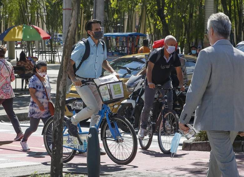 personas movilizándose en en bicicleta por una ciclovía de la ciudad