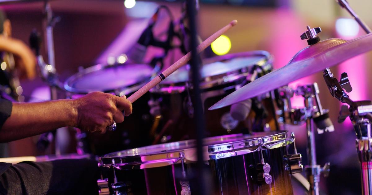 Cropped image of a musician playing drum set on the stage.