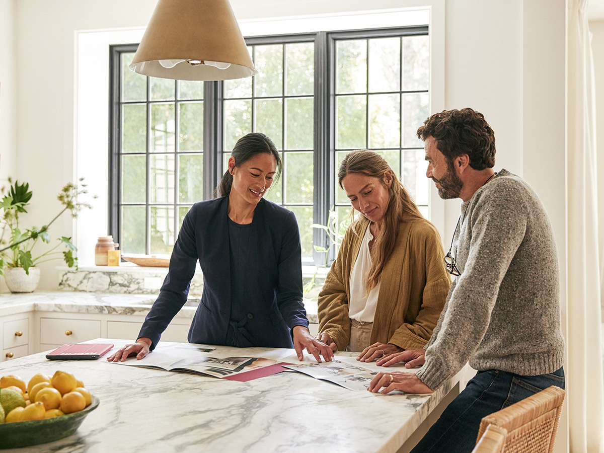 Redfin agent with two customers outside of home