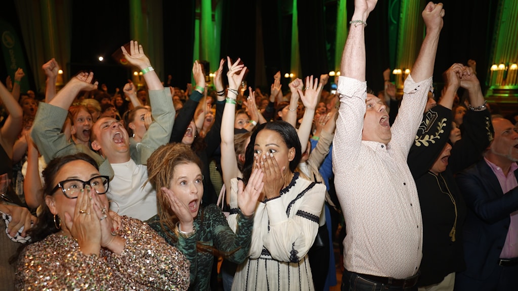 Green party candidates and supporters react with surprise and joy on seeing the exit poll on election night.